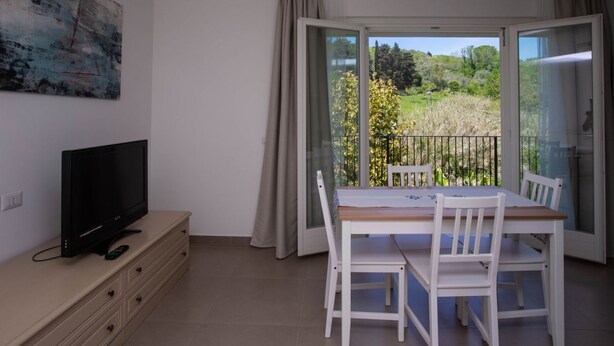 A room with a TV on a dresser, a balcony with a table and chairs, and a painting on the wall. - S160 - Sirolo, brand new two-room apartment with terrace (Sirolo)