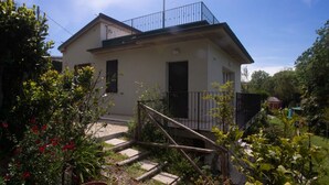 A two-story house with a balcony, surrounded by greenery and a wooden staircase. - S160 - Sirolo, brand new two-room apartment with terrace (Sirolo)
