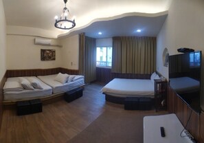 A hotel room with a bed, a sofa bed, a TV, and an air conditioning unit. - No.98 B&B (Hualien City)