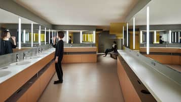A modern restroom with multiple sinks, mirrors, and benches.
