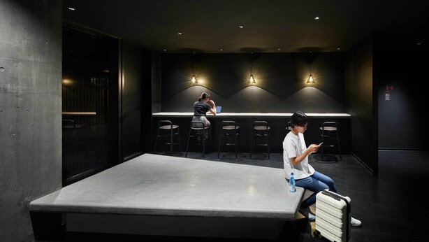 Una habitación de hotel moderna con una cama grande, un escritorio y una zona de estar con sillones.