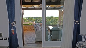 A room with a sliding glass door leading to an outdoor patio area. - Villa Cinzia sea view (Porto Tramatzu)