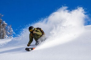 Una persona practica snowboard en una ladera nevada.