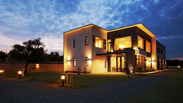 A modern two-story house with a well-lit exterior and a landscaped front yard. - Easy Inn (Hengchun)
