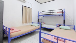 Un dormitorio con literas, una ventana con cortinas, un equipo de aire acondicionado y suelo de baldosas.