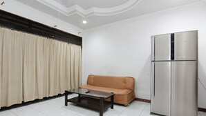 Una habitación con sofá, una mesita de centro y un refrigerador.
