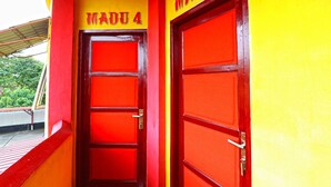 Entrada de un edificio con dos puertas rojas, identificadas con las etiquetas "MADU 4" y "MADU 5".