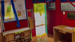 Una habitación con cama, escritorio, silla, pizarra y ventana con cortinas.