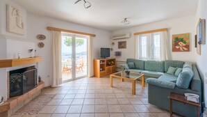 Una sala de estar con chimenea, un sofá, una mesa de centro y un televisor.