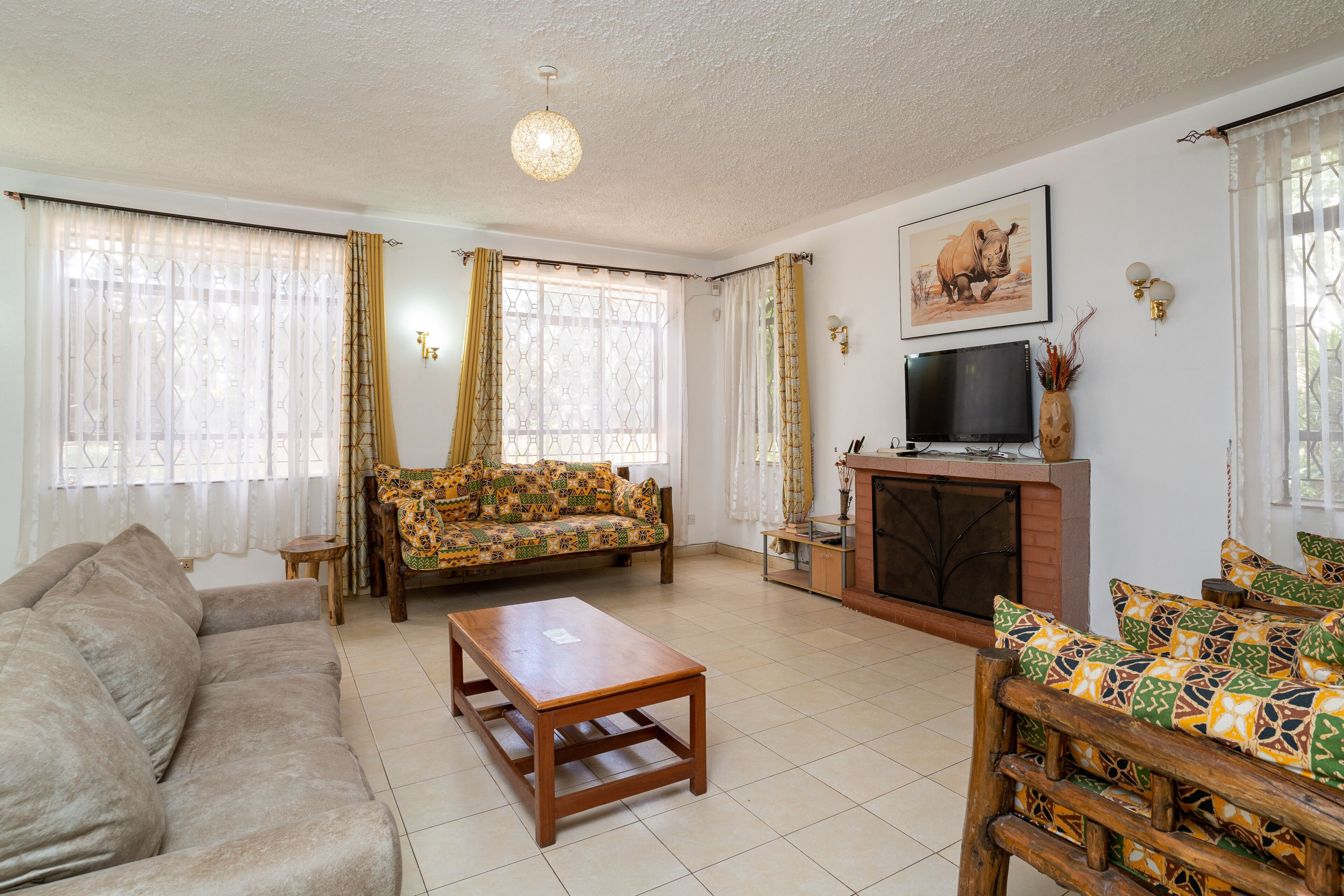 A living room with a sofa, a coffee table, a TV, and a fireplace.
