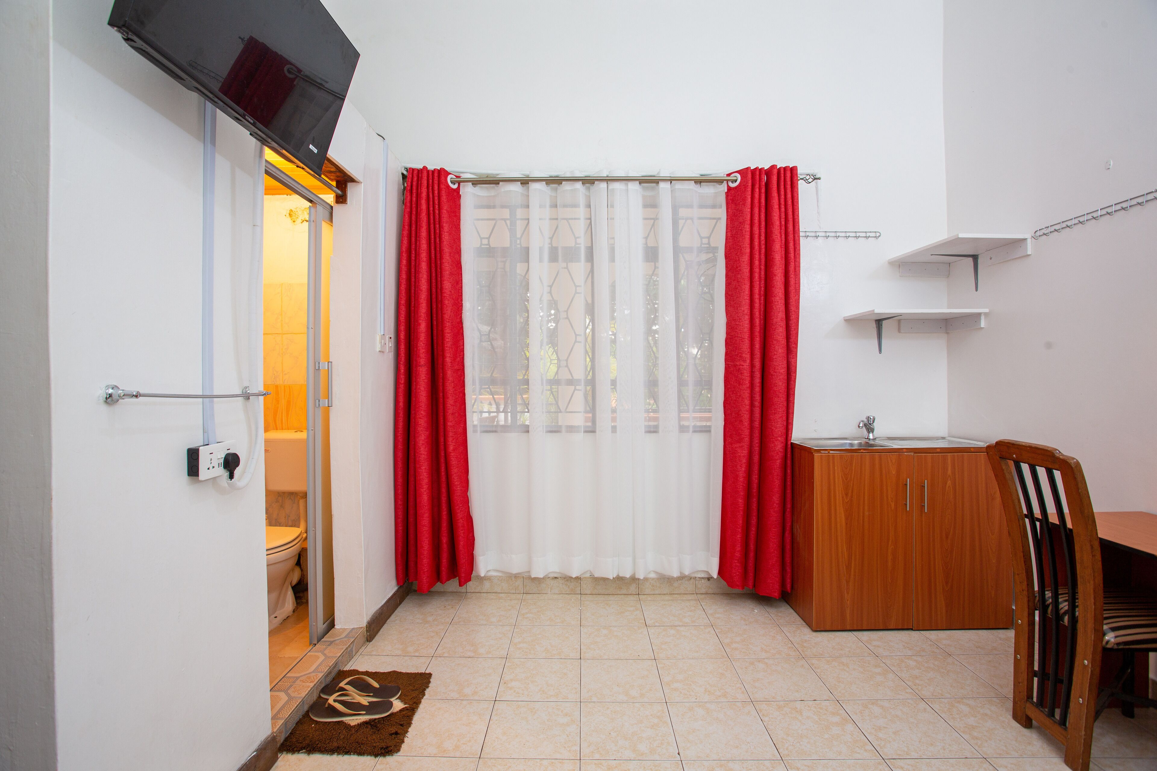 A bathroom with a toilet, a sink, and a shower area.