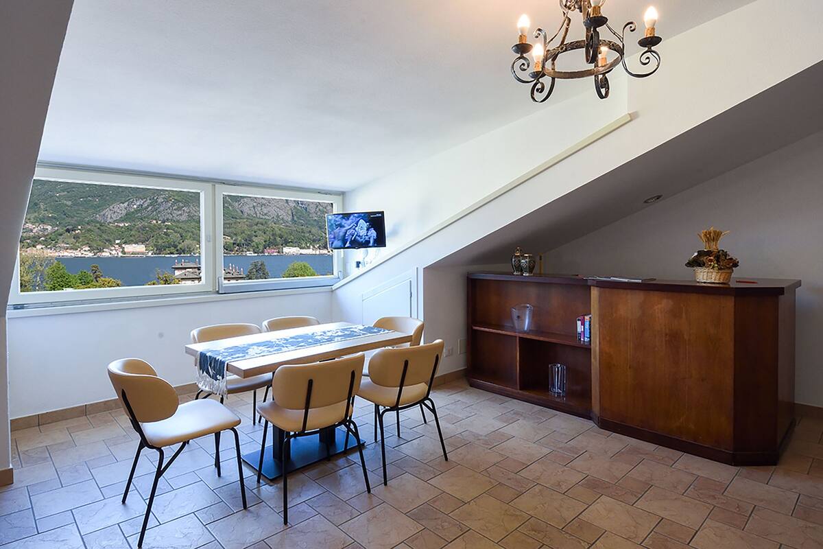 A dining area with a table and chairs, a wooden cabinet, and a TV screen.