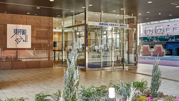 A hotel entrance with a glass door, a signboard with Japanese characters, and a tiled floor. - Toyoko Inn Osaka Hankyu Juso Station Nishi 2 (Osaka)