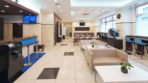 A hotel lobby with a reception desk, seating area, and a large window. - Toyoko Inn Osaka Hankyu Juso Station Nishi 2 (Osaka)
