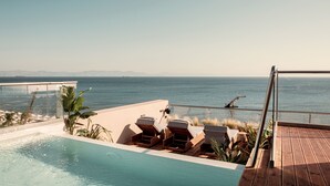 A poolside area with lounge chairs and a view of the sea. - More Meni City Beach Rhodes (Rhodes)