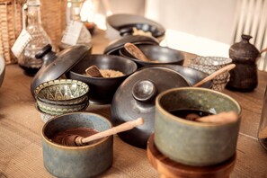 Variedad de juegos de té y recipientes de cerámica sobre una mesa de madera.