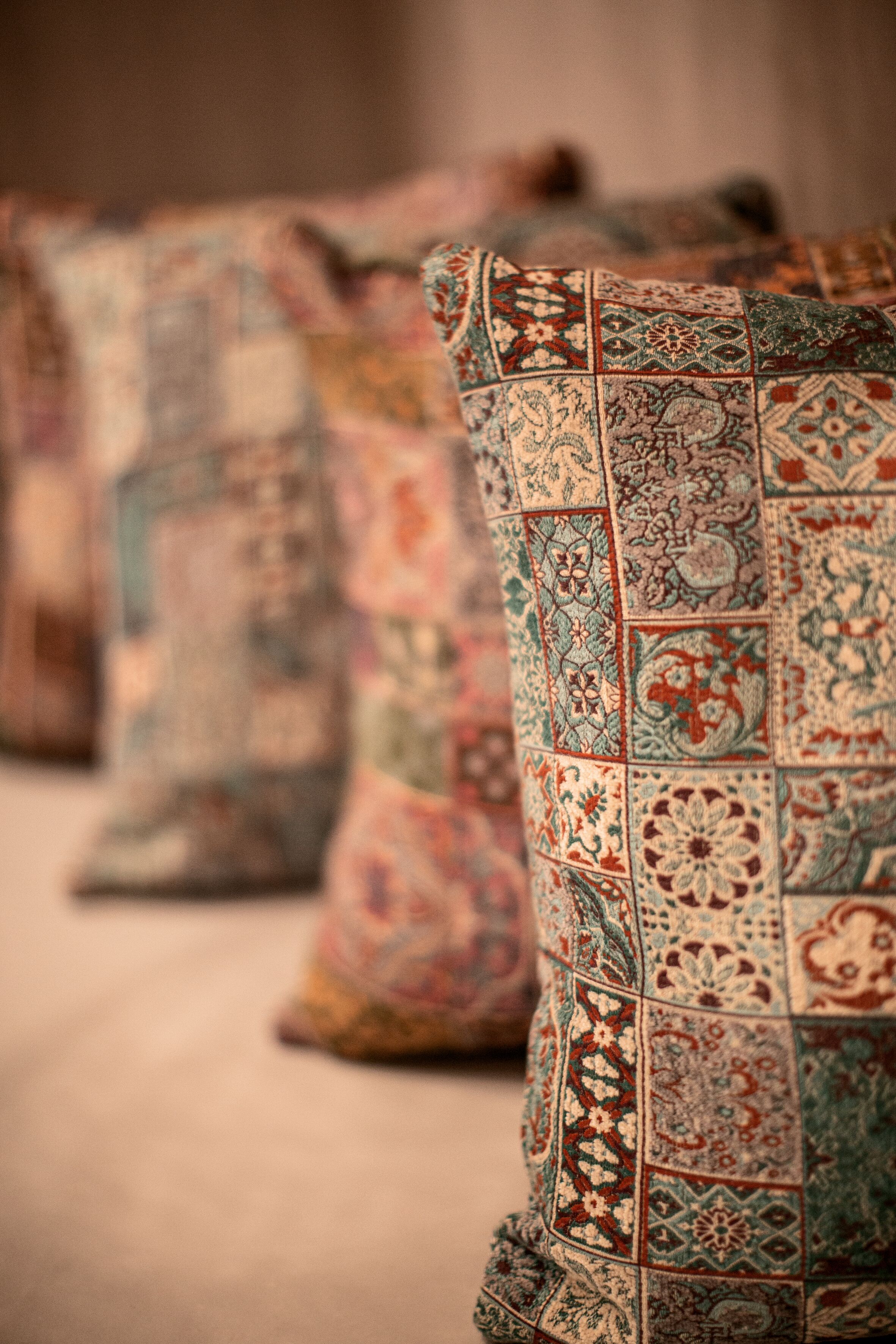 A row of intricately patterned cushions on a bed.
