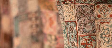 A row of intricately patterned cushions on a bed.