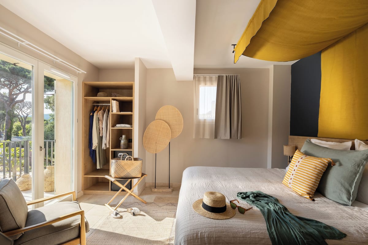 A bedroom with a bed, a wardrobe, a chair, and a window.