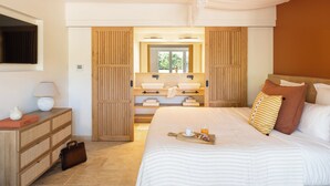 A bedroom with a large bed, a bedside table with a lamp, a dresser, and a mirror. - Hôtel L'Escalet  (Ramatuelle)