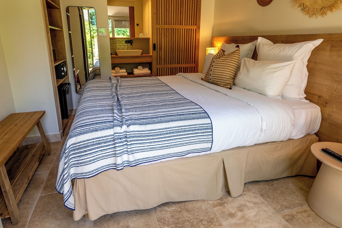 Ein Schlafzimmer mit einem Bett, einem Nachttisch und einer hölzernen Bank.