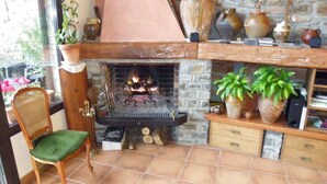 Una habitación acogedora con chimenea, un sillón y varios objetos decorativos.
