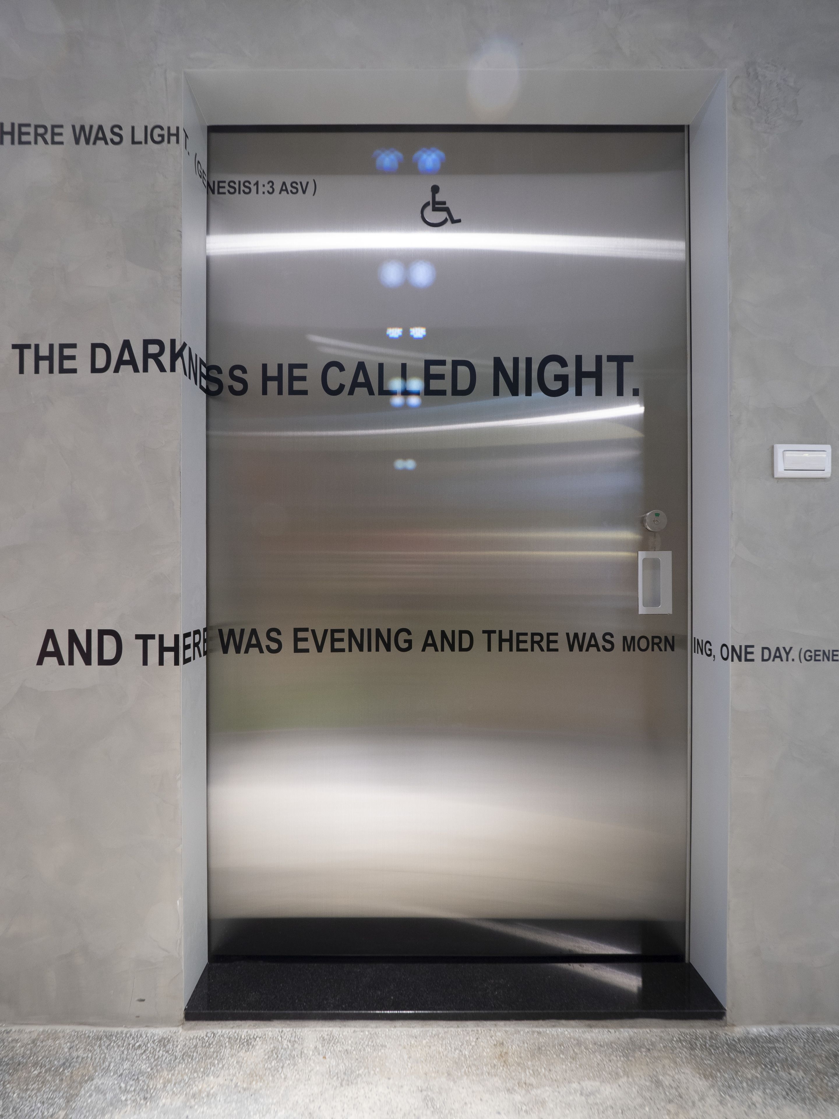 An elevator with a metallic interior and a wheelchair accessibility symbol.