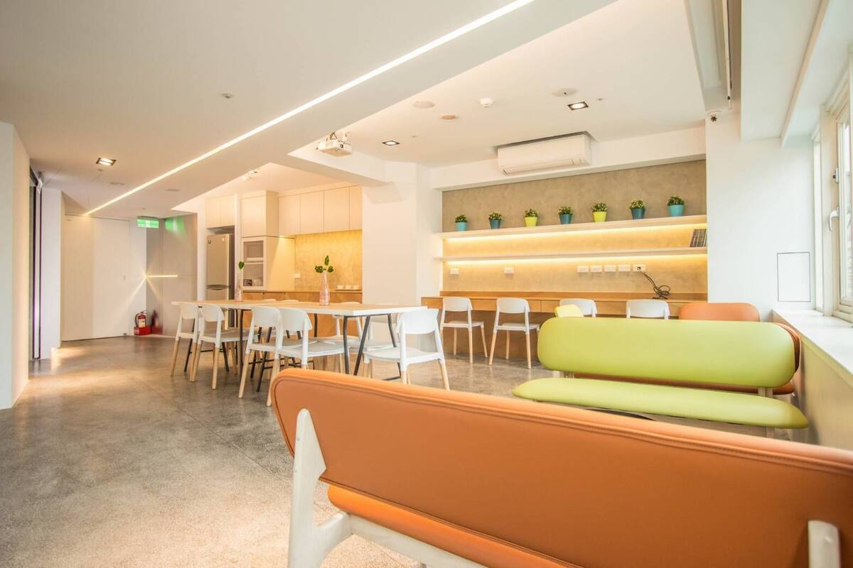 A modern waiting area with a reception desk, seating, and a fire extinguisher.