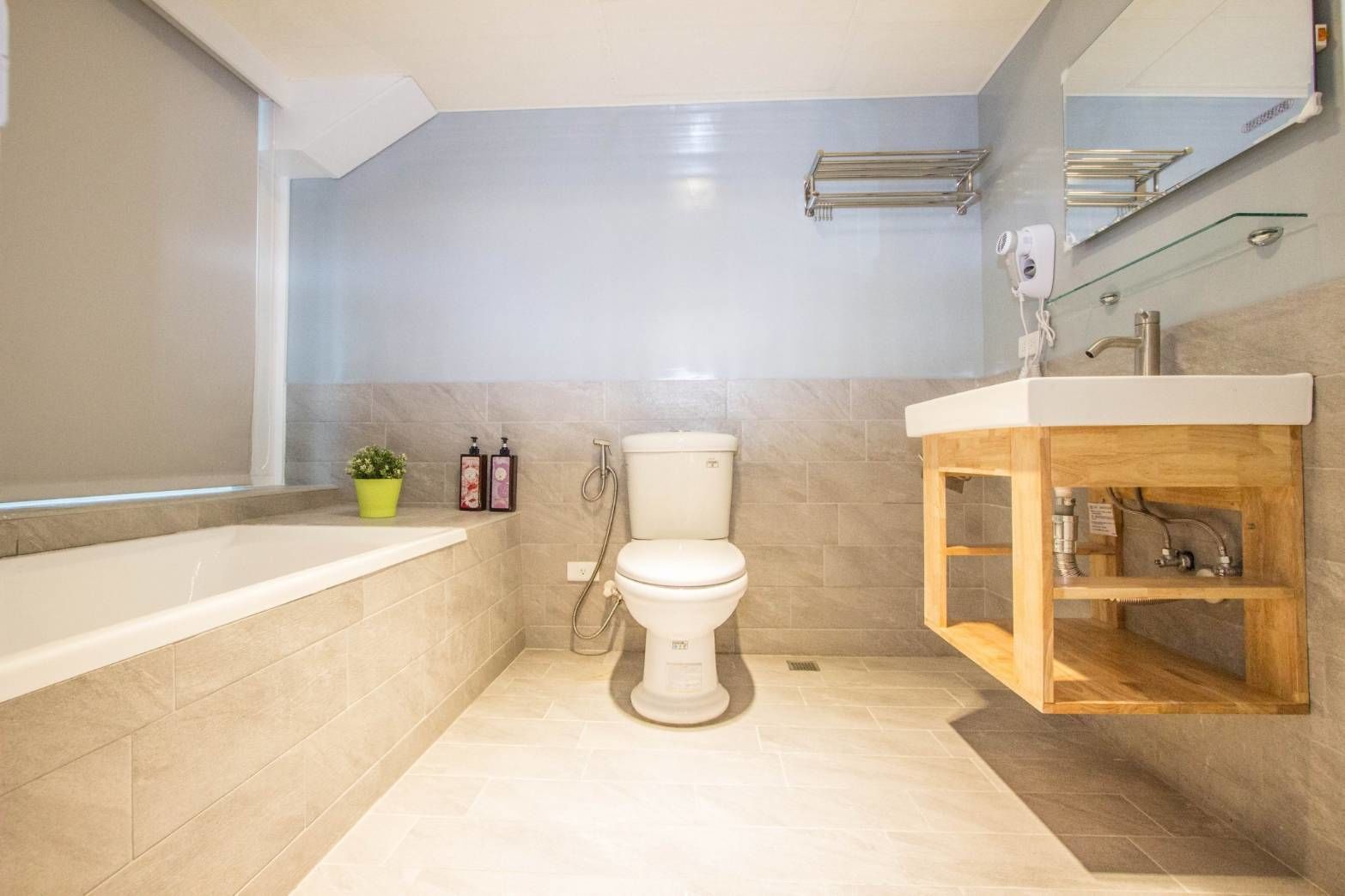 Un baño moderno con bañera, inodoro y tocador de madera.