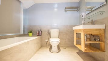Un baño moderno con bañera, inodoro y tocador de madera.