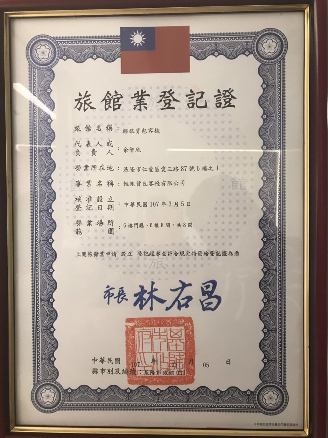 A framed certificate with Chinese text, a flag, and a seal.
