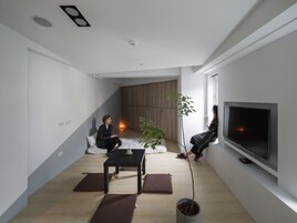 Una sala de estar moderna con un televisor de pantalla plana, una mesa de centro y una planta en maceta.