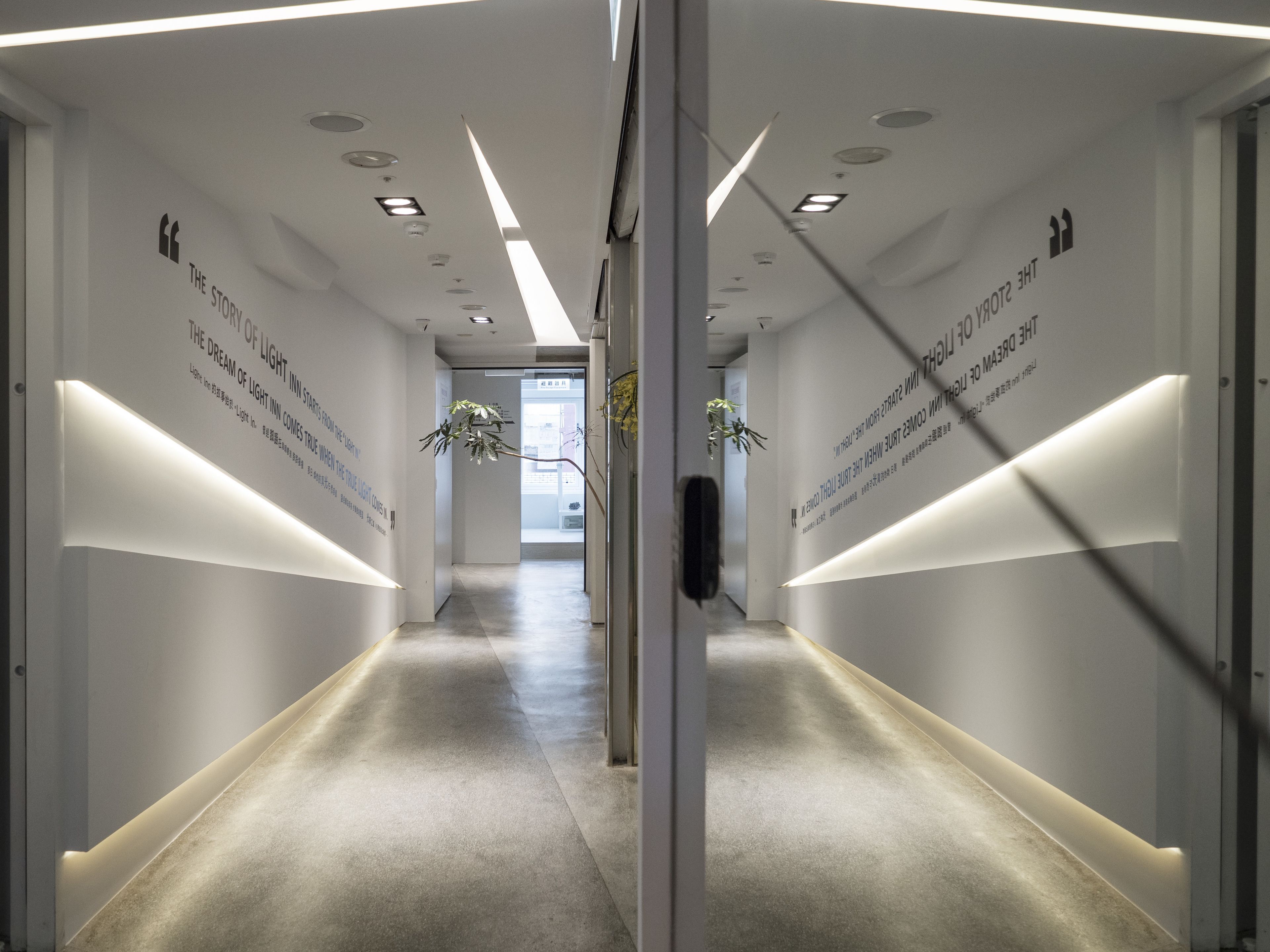 Un pasillo moderno con iluminación empotrada y señalización direccional.