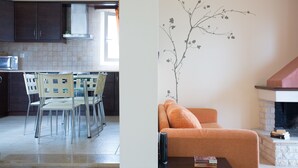 Una cocina moderna con armarios oscuros, un microondas y un comedor con sillas y una mesa.