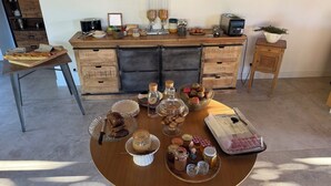 Ein Esstisch mit verschiedenen Speisen, einer Kaffeemaschine und einer Brokkasten.