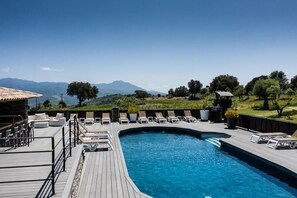 Una piscina al aire libre de temporada, sombrillas