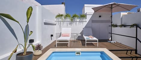 Una piscina al aire libre de temporada, sillones reclinables de piscina