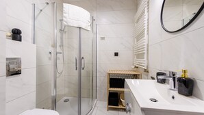 A modern bathroom with a glass-enclosed shower, a white sink, and a mirror. - Izerska Przygoda - Apartamenty 5d (Swieradow-Zdroj)