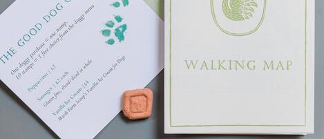 En karta för promenader och en låda med hundkex, med ett hundkex placerat på ett bord.