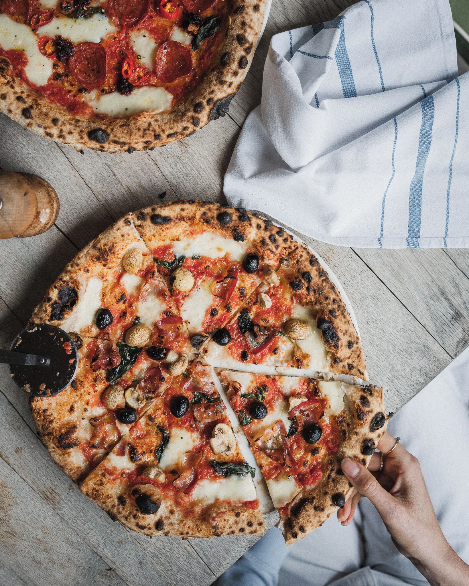 A pizza with various toppings on a wooden surface.