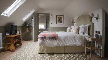 A bedroom with a bed, bedside tables, a desk, a mirror, and a window.