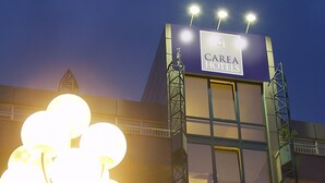 A building with a sign reading "CAREA HOTELS" and a street lamp in the foreground.