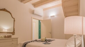 A bedroom with a bed, a dresser, a mirror, and an air conditioning unit. - Casa Manoli Varenna (Varenna)