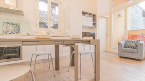 A modern kitchen with a central island, bar stools, and a dining table. - Casa Manoli Varenna (Varenna)