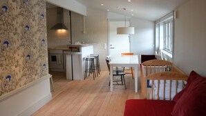 A modern kitchen with a central island, bar stools, and a dining table.