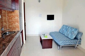 Suite ejecutiva, vista a la colina | Área de sala de estar | Televisión LED de 32 pulgadas con canales por cable y televisión 