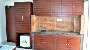 Eine Küche mit Holzausstattung, einer Backstein-Spritzschutzwand und einem integrierten Spülbecken.