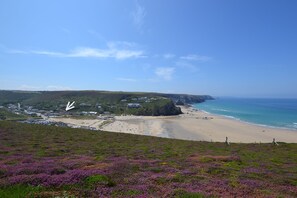 Eine Küstenlandschaft mit Strand, Häusern und einer Klippe.