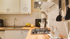 A modern kitchen with white cabinets, a stainless steel sink, a gas stove, and a dishwasher.