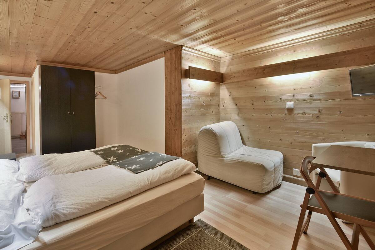 Une chambre à coucher avec un lit, une chaise et un bureau.